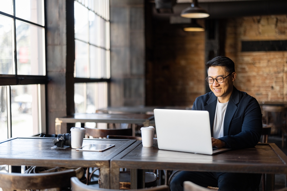 Asian,Businessman,Typing,On,Laptop,During,Work,In,Cafe.,Concept