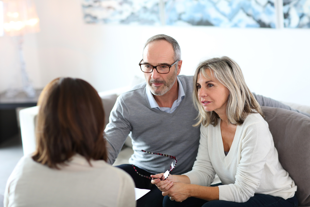 A couple meets with a financial advisor in their home.