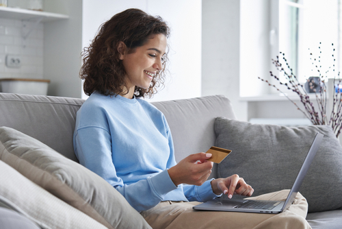 Happy,Hispanic,Young,Woman,Consumer,Holding,Credit,Card,And,Laptop